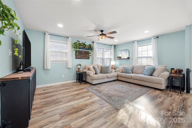 living room featuring hardwood / wood-style flooring, ceiling fan, and a healthy amount of sunlight