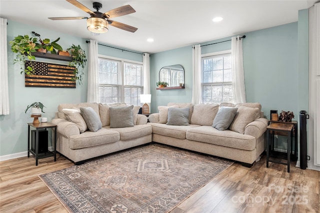 living room with hardwood / wood-style floors, a wealth of natural light, and ceiling fan