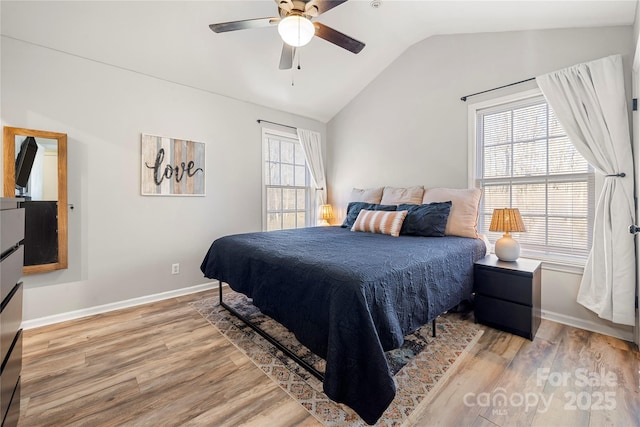 bedroom featuring multiple windows, ceiling fan, hardwood / wood-style floors, and vaulted ceiling