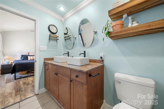 bathroom featuring tile patterned floors, crown molding, vanity, and toilet