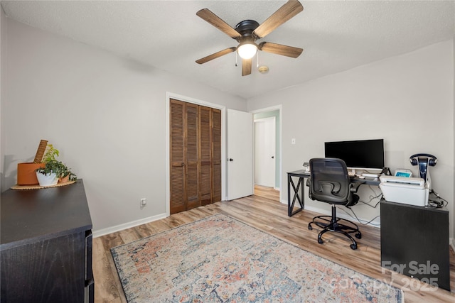 office space featuring hardwood / wood-style floors, ceiling fan, and a textured ceiling