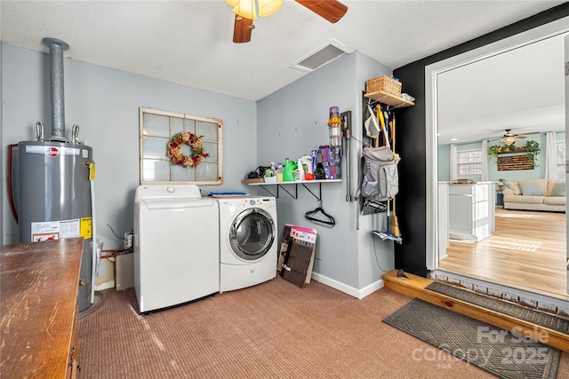 laundry area with carpet, washing machine and dryer, a textured ceiling, and water heater