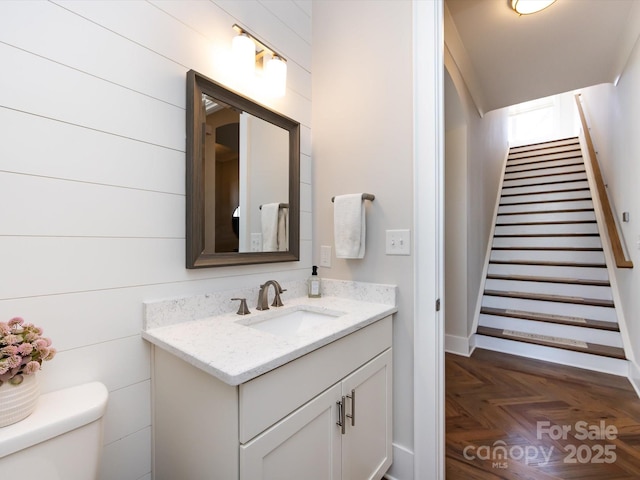 half bathroom with vanity and toilet