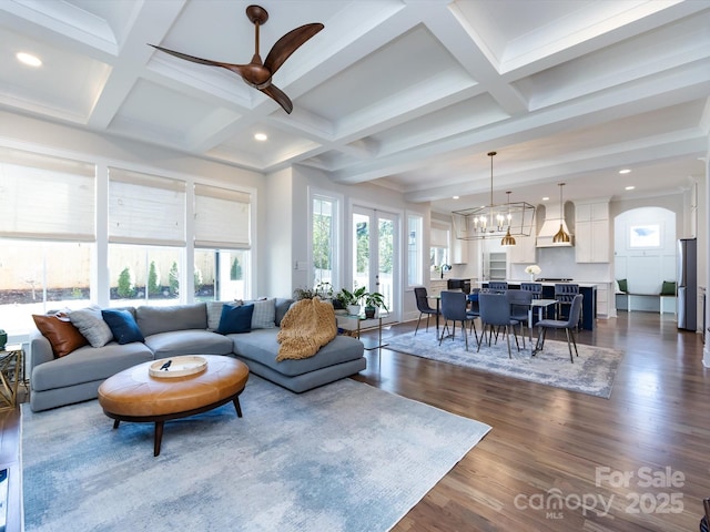 living area featuring dark wood-style flooring, coffered ceiling, beamed ceiling, and an inviting chandelier