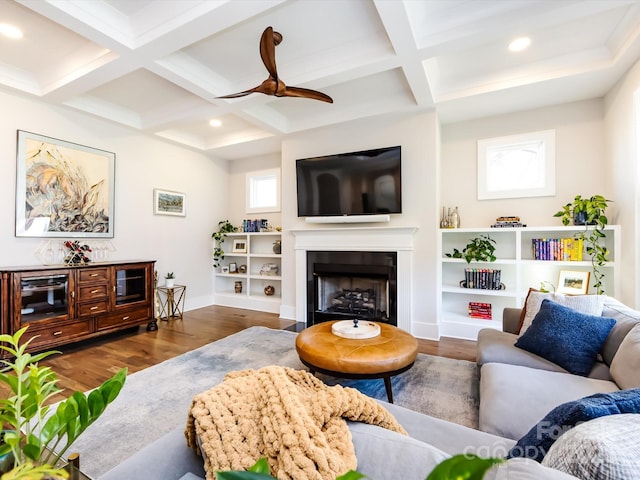 living room with coffered ceiling, a fireplace, beamed ceiling, and wood finished floors