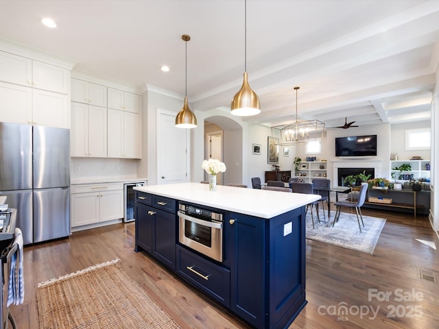 kitchen featuring wine cooler, blue cabinets, a fireplace, white cabinetry, and appliances with stainless steel finishes