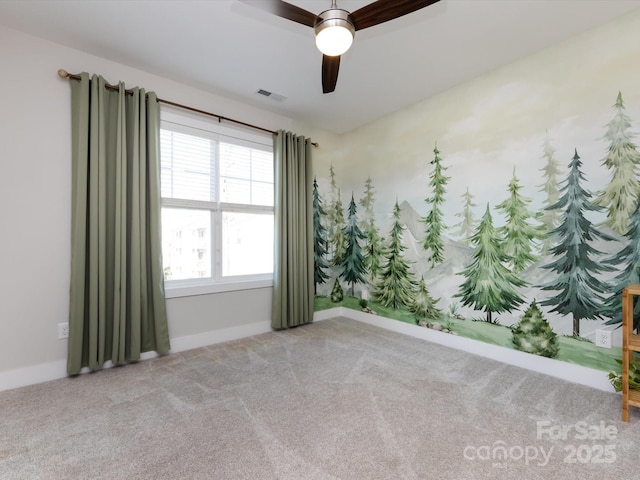 spare room with carpet, visible vents, ceiling fan, and baseboards