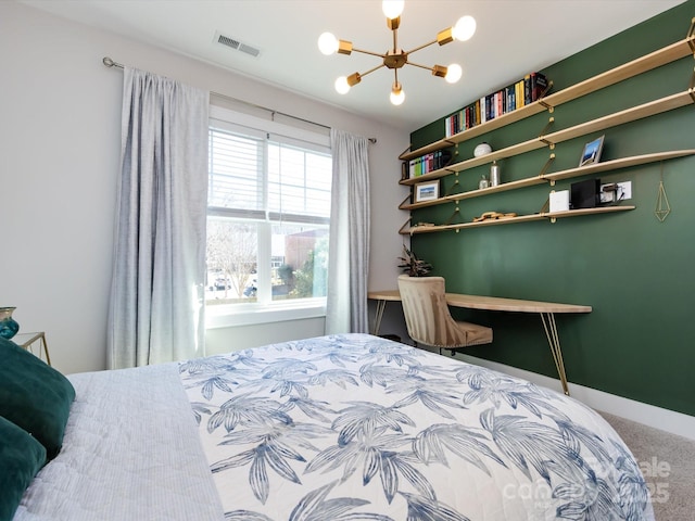 carpeted bedroom featuring baseboards, visible vents, and a notable chandelier