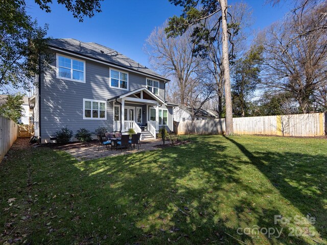 back of property with a fenced backyard and a yard