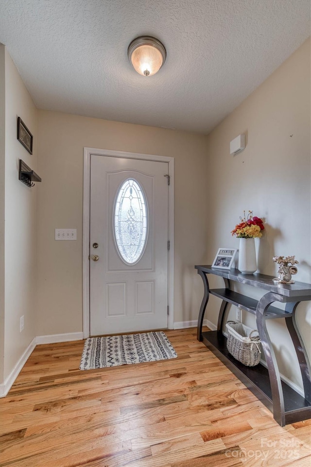 entrance foyer featuring a textured ceiling and light wood-type flooring