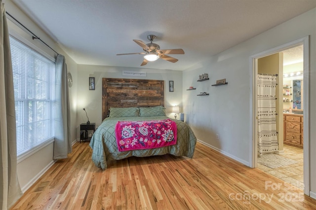 bedroom with ensuite bathroom, ceiling fan, and light wood-type flooring