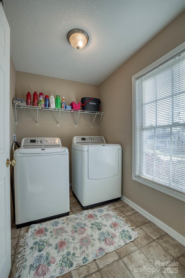 washroom with washing machine and clothes dryer and a textured ceiling