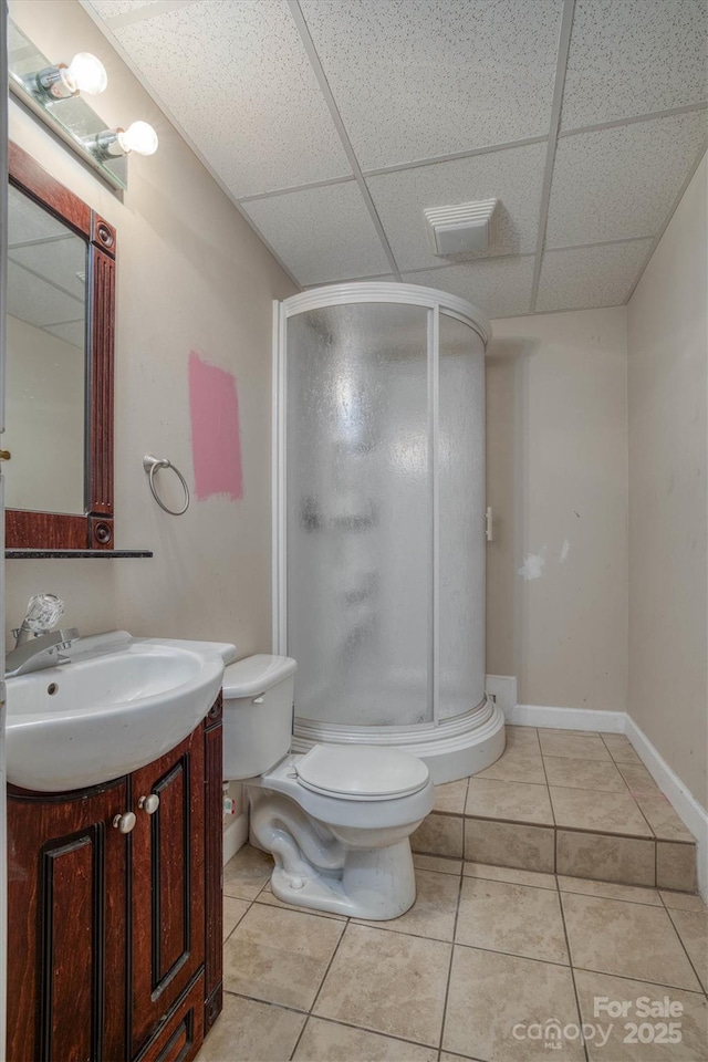 bathroom featuring a paneled ceiling, vanity, toilet, and tile patterned floors