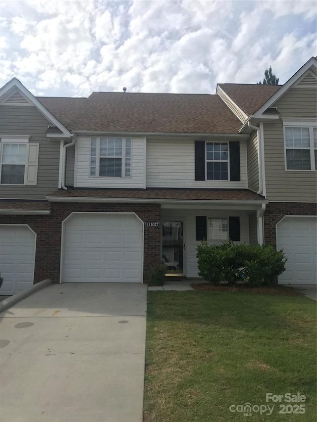 townhome / multi-family property featuring a garage and a front yard