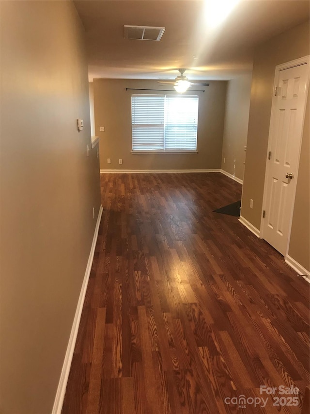 unfurnished room featuring ceiling fan and dark wood-type flooring