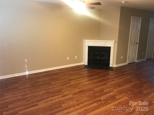 unfurnished living room featuring dark hardwood / wood-style flooring and ceiling fan