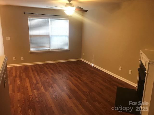 unfurnished room with dark hardwood / wood-style floors and ceiling fan