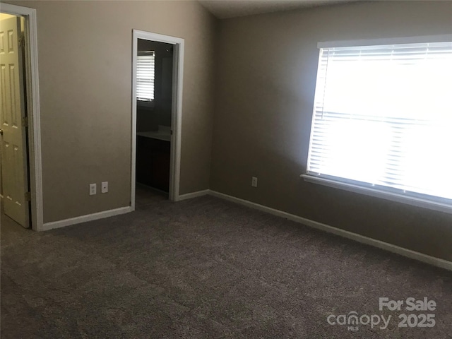 unfurnished bedroom with dark colored carpet