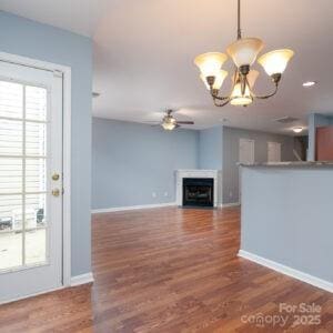 unfurnished living room featuring dark wood-type flooring, plenty of natural light, and ceiling fan with notable chandelier