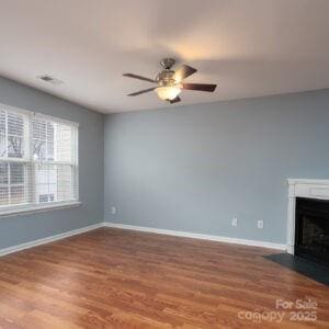 unfurnished living room with ceiling fan and wood-type flooring