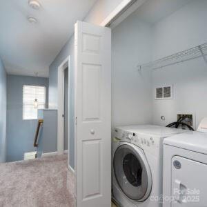 clothes washing area with carpet floors and washing machine and dryer