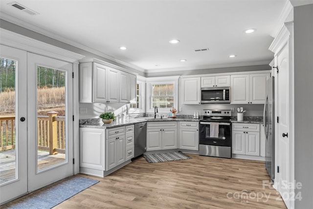 kitchen with light hardwood / wood-style floors, white cabinetry, sink, and appliances with stainless steel finishes