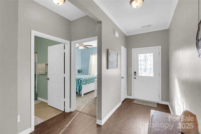 foyer with wood-type flooring, ceiling fan, and crown molding