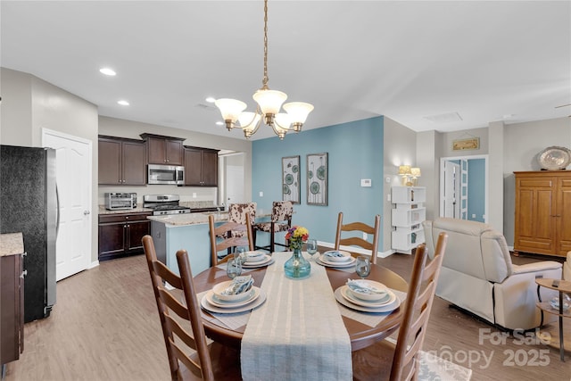 dining space with a chandelier and light wood-type flooring