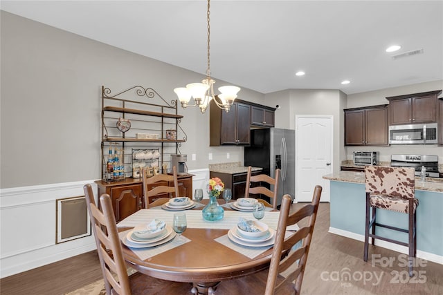 dining room featuring hardwood / wood-style floors and a chandelier