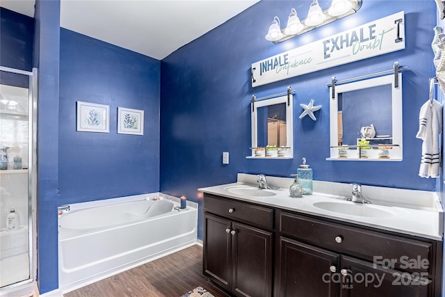 bathroom with wood-type flooring, vanity, and independent shower and bath