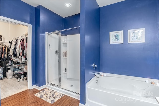 bathroom with hardwood / wood-style flooring and independent shower and bath