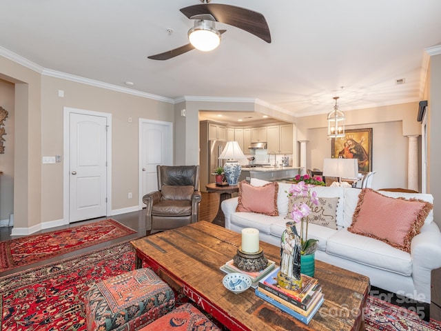 living room featuring crown molding and ceiling fan with notable chandelier