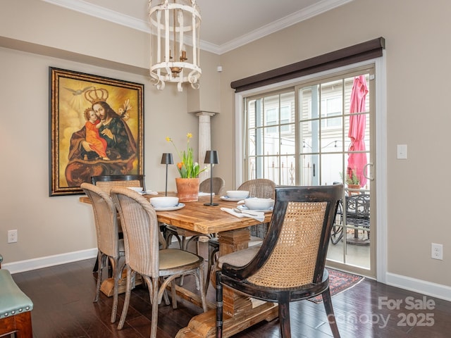 dining space with dark hardwood / wood-style floors, an inviting chandelier, crown molding, and ornate columns