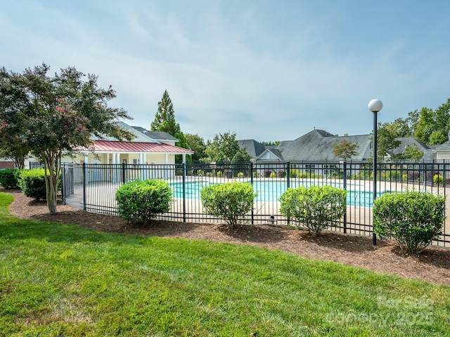 view of pool with a lawn