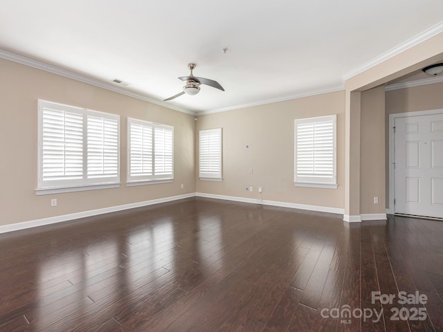 spare room featuring wood finished floors, a ceiling fan, baseboards, visible vents, and crown molding