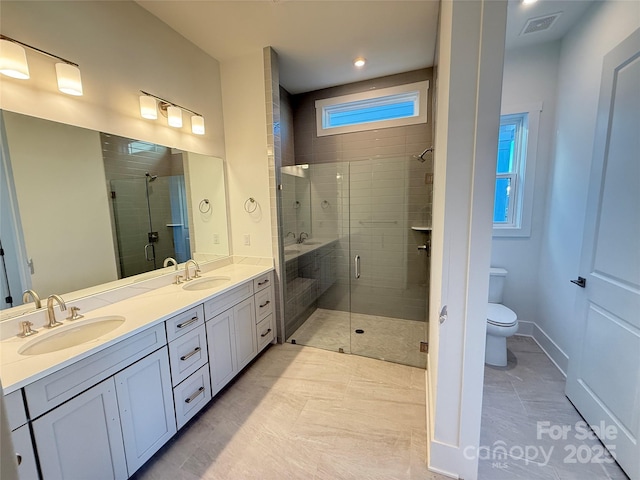 bathroom with vanity, a shower with door, tile patterned flooring, and toilet