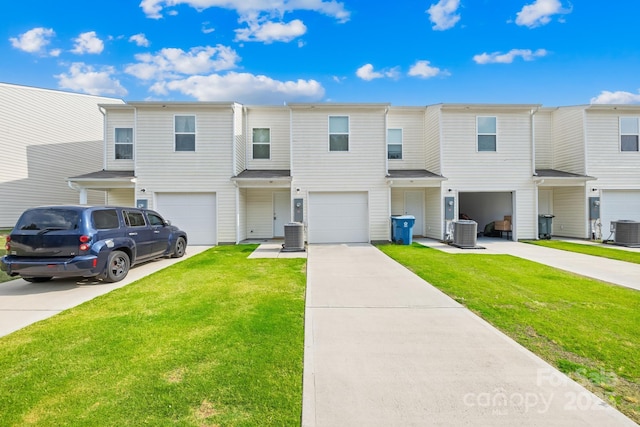 townhome / multi-family property with central AC, a front lawn, and a garage