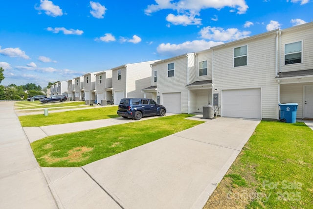 townhome / multi-family property with central AC, a garage, and a front lawn