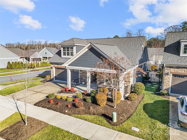 view of front of home featuring a porch, a garage, and a front lawn