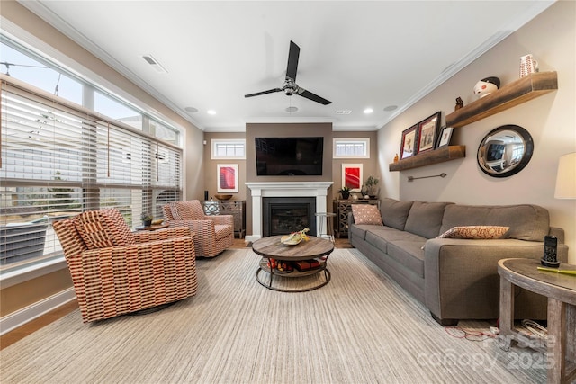 living room with crown molding, ceiling fan, and light hardwood / wood-style floors