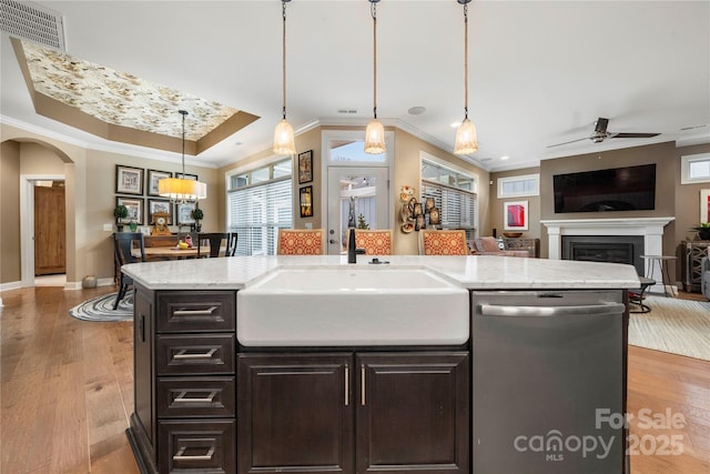 kitchen with pendant lighting, a center island with sink, sink, stainless steel dishwasher, and ceiling fan