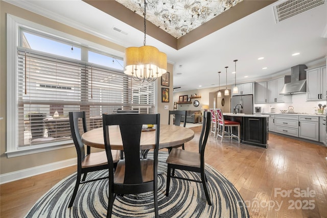 dining room featuring light hardwood / wood-style floors, an inviting chandelier, and ornamental molding