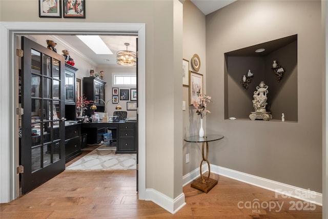 interior space featuring hardwood / wood-style flooring, crown molding, and a notable chandelier