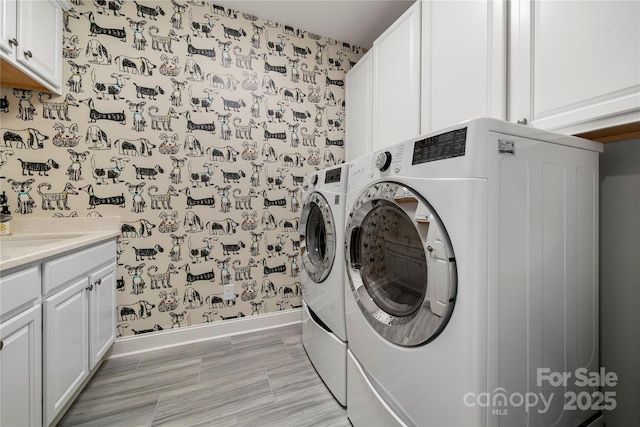 washroom featuring washer and dryer, cabinets, and sink