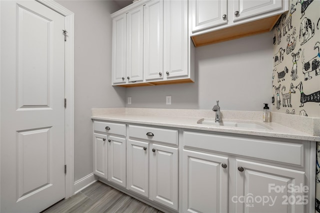 laundry room featuring light wood-type flooring and sink