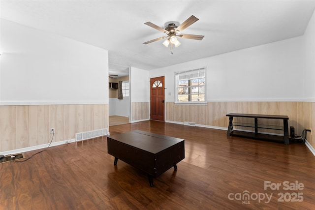 living room with dark wood-type flooring and ceiling fan