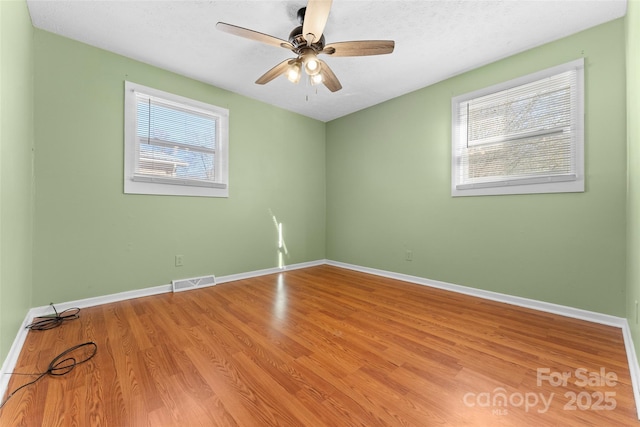 spare room with hardwood / wood-style flooring, a textured ceiling, and ceiling fan