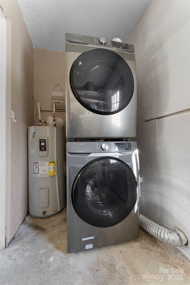 laundry room with a textured ceiling, water heater, and stacked washer and dryer