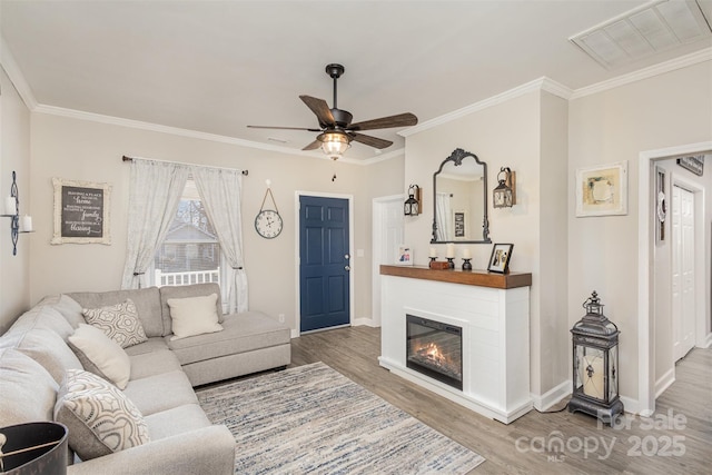 living room with ceiling fan, hardwood / wood-style flooring, and ornamental molding