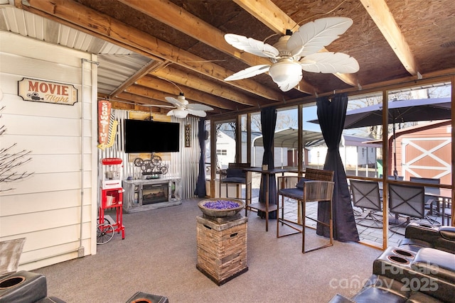 living room featuring ceiling fan, wood walls, and carpet floors